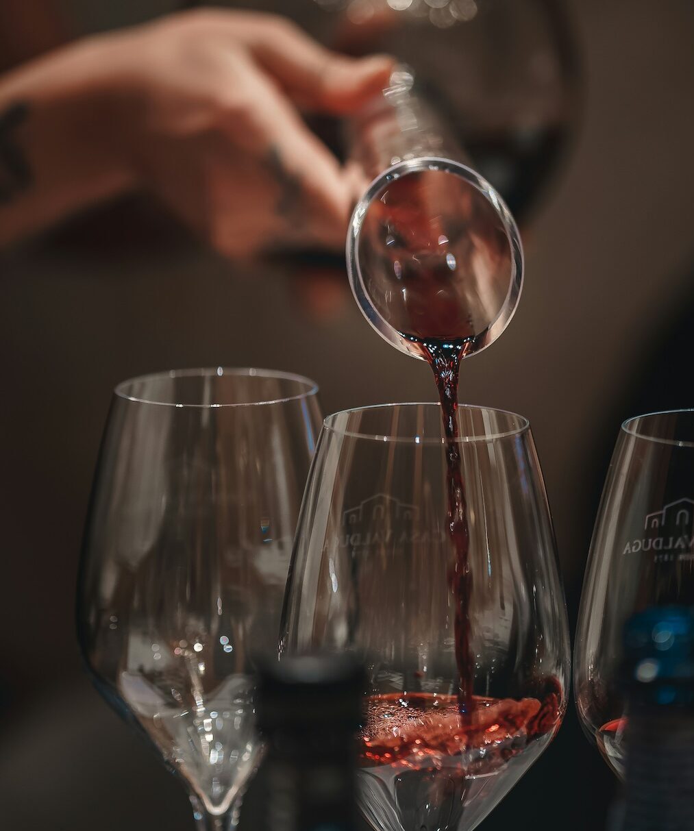 A hand pouring red wine into glasses at Viento, a fine dining restaurant in Hood River