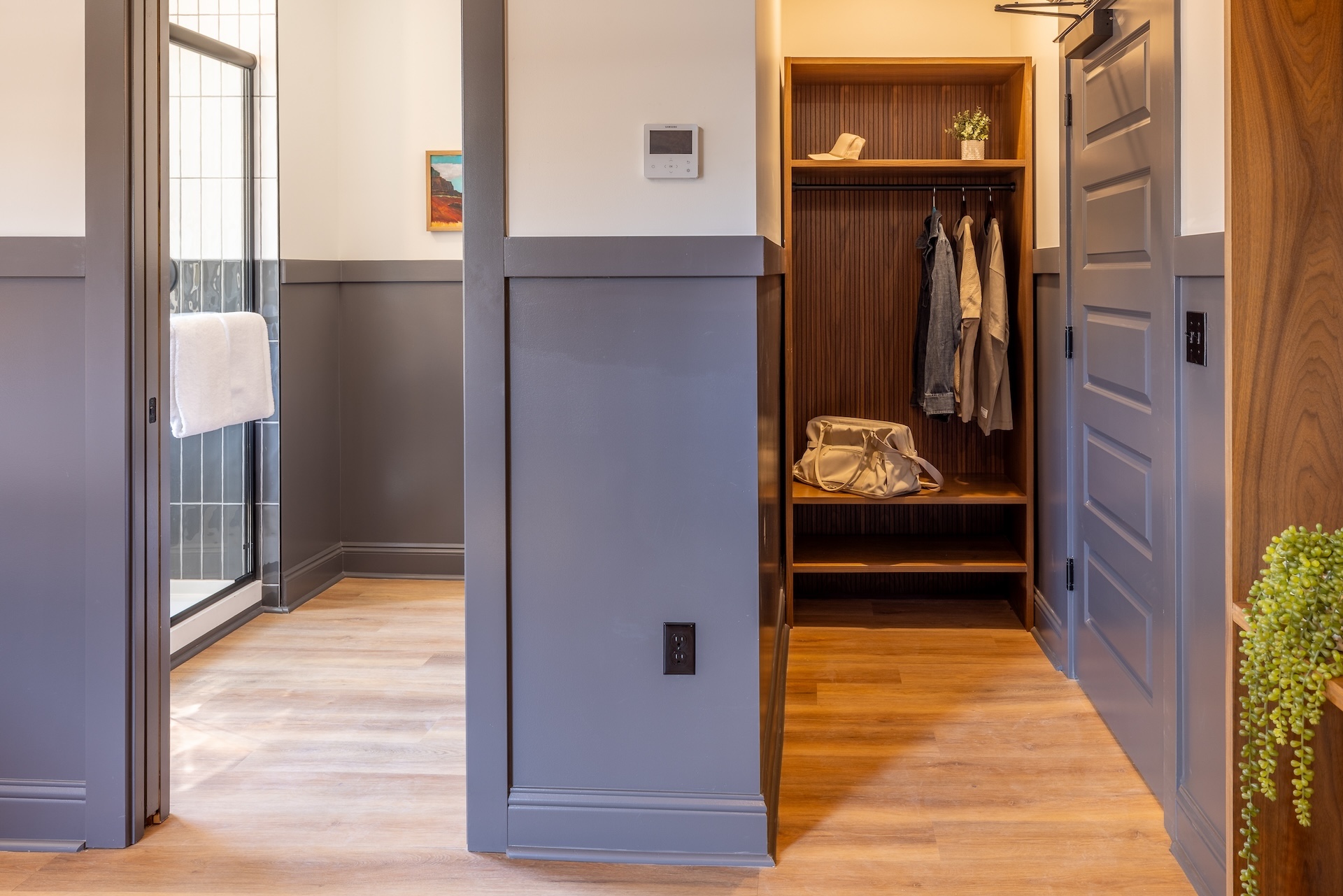 City View King guest room at Lightwell Hotel & Spa in Hood River featuring modern closet with wood finishes, hanging space, and open shelving.