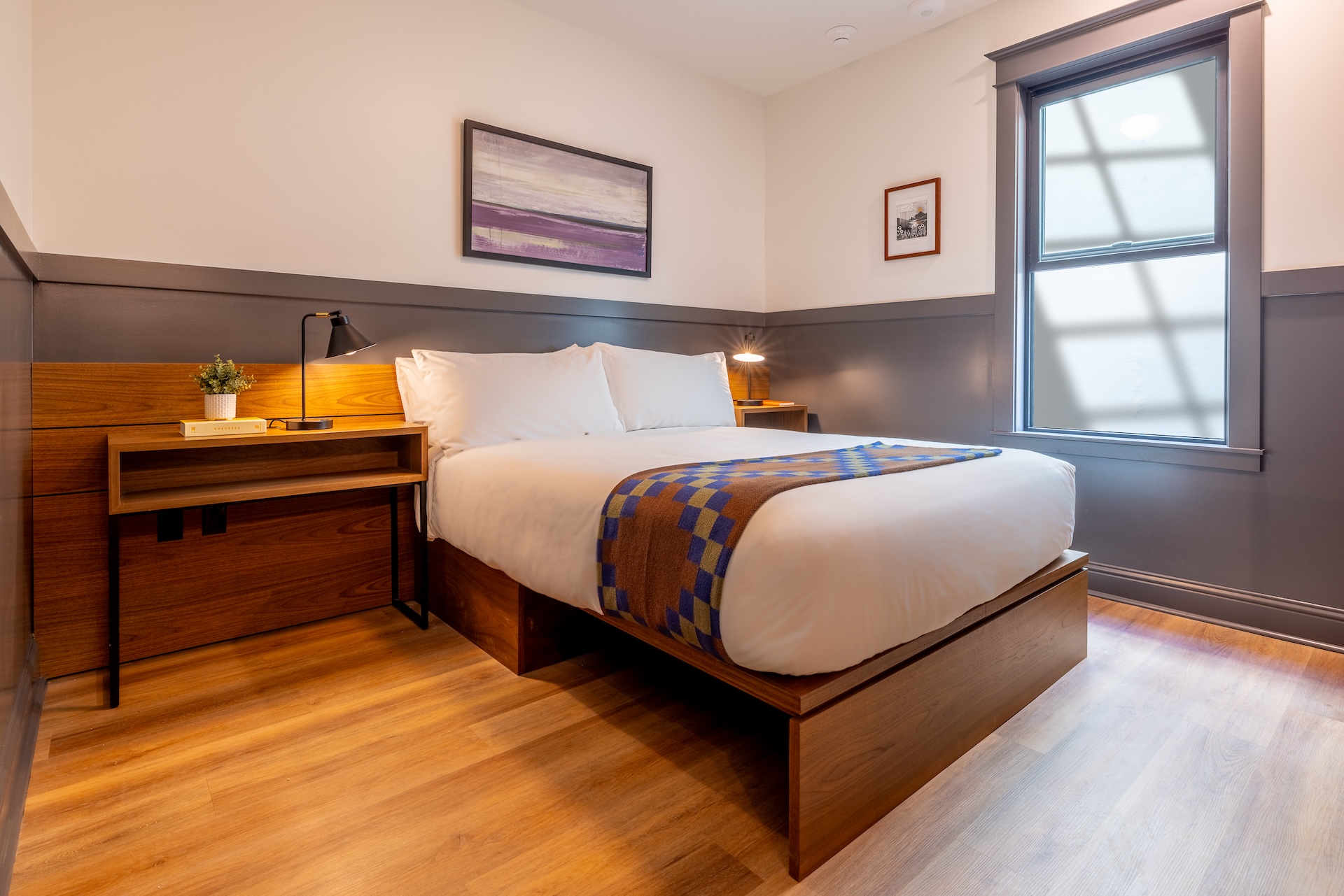 Lightwell Hotel & Spa Queen guest room in Hood River with modern design, wood furnishings, and cozy bedding.
