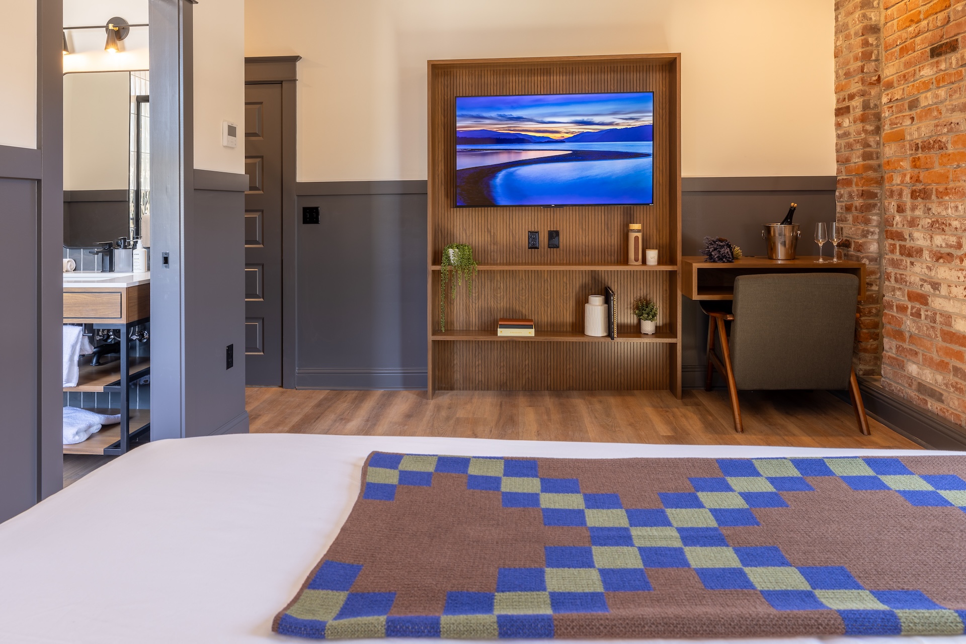 River View King room at Lightwell Hotel Hood River with flat-screen TV, desk, and modern bathroom access.