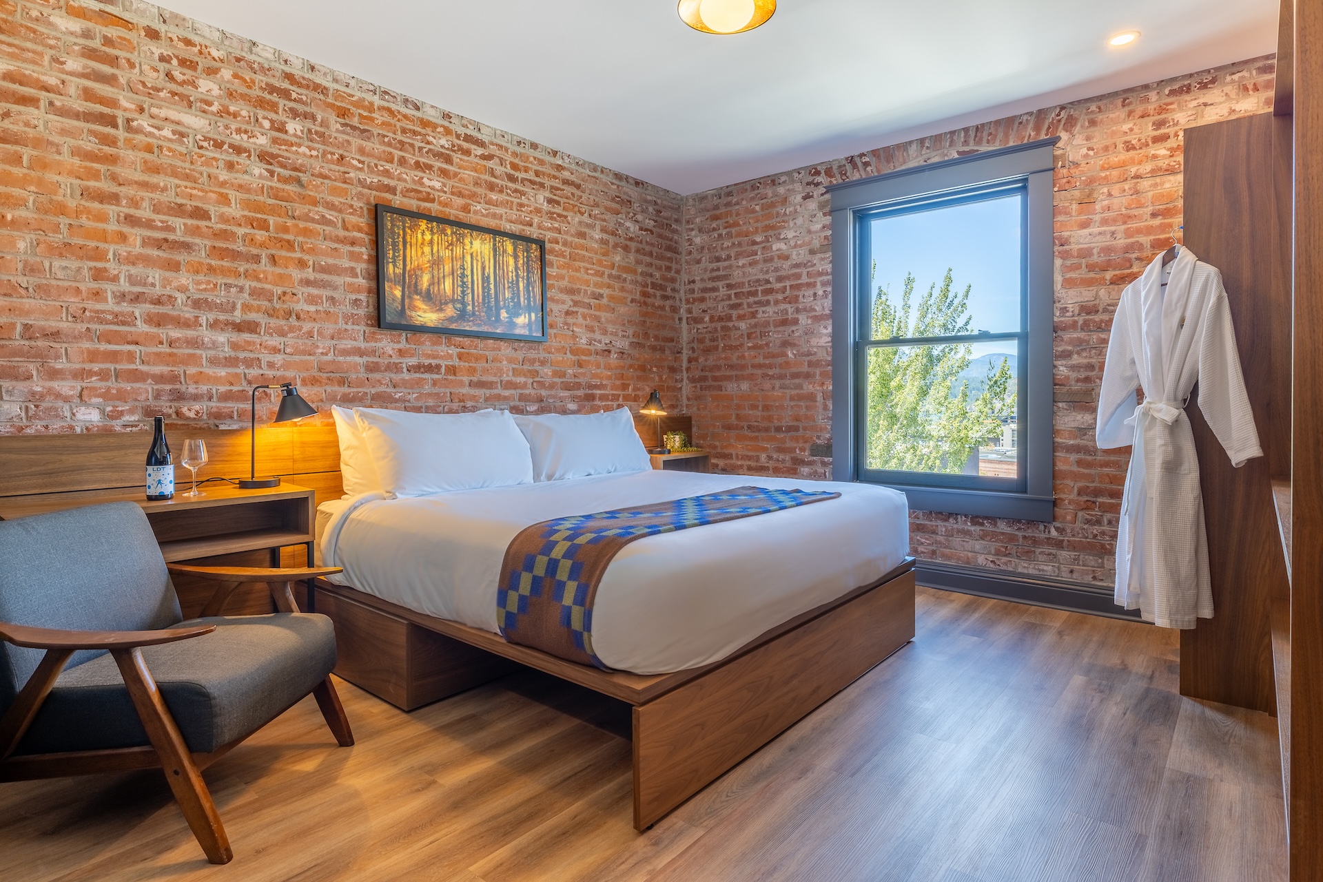 River View King room at Lightwell Hotel Hood River with brick walls, king bed, and large window view.