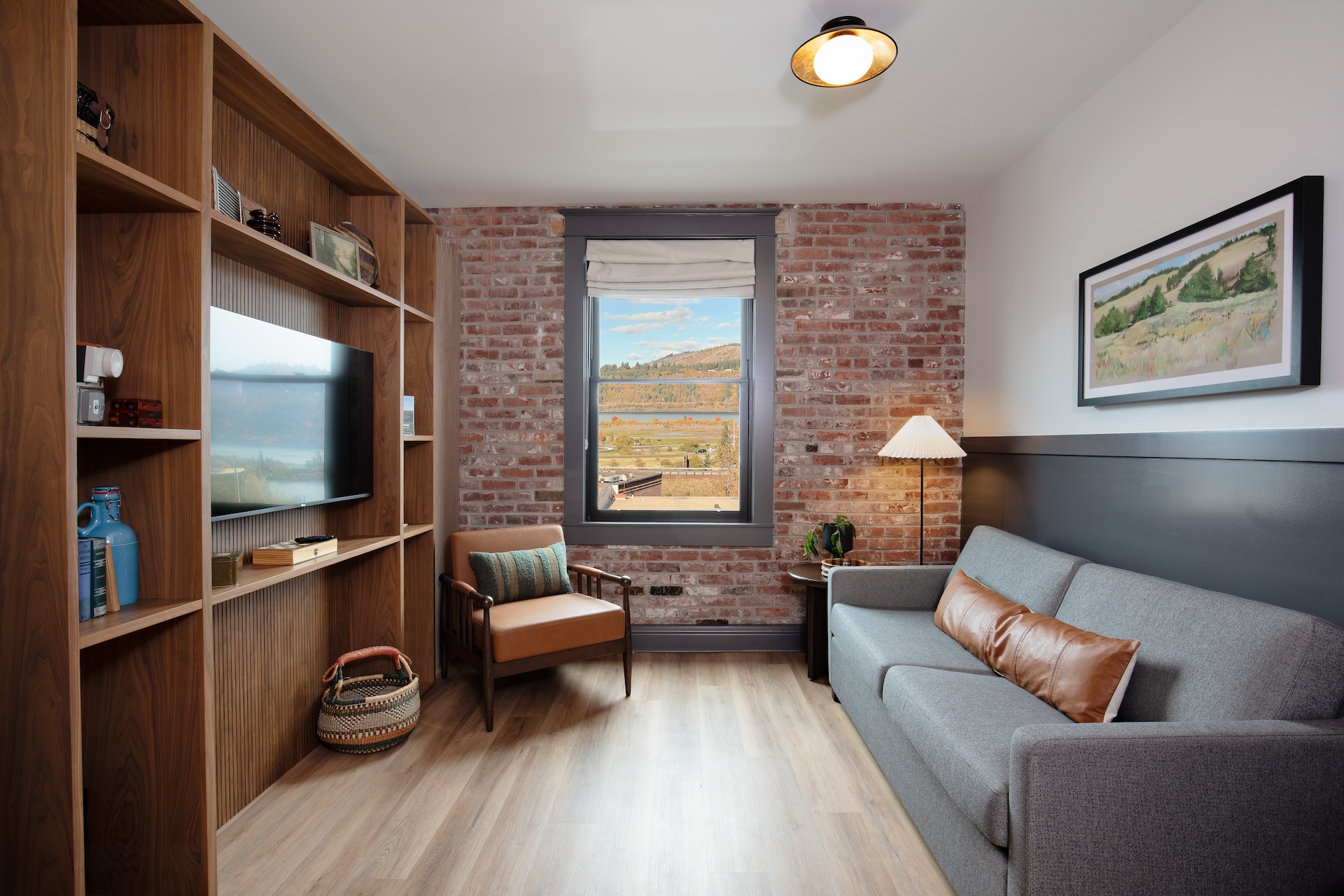 Interior of the Sandbar Suite featuring modern décor, large windows overlooking the Columbia River, and seating area with sofa bed.