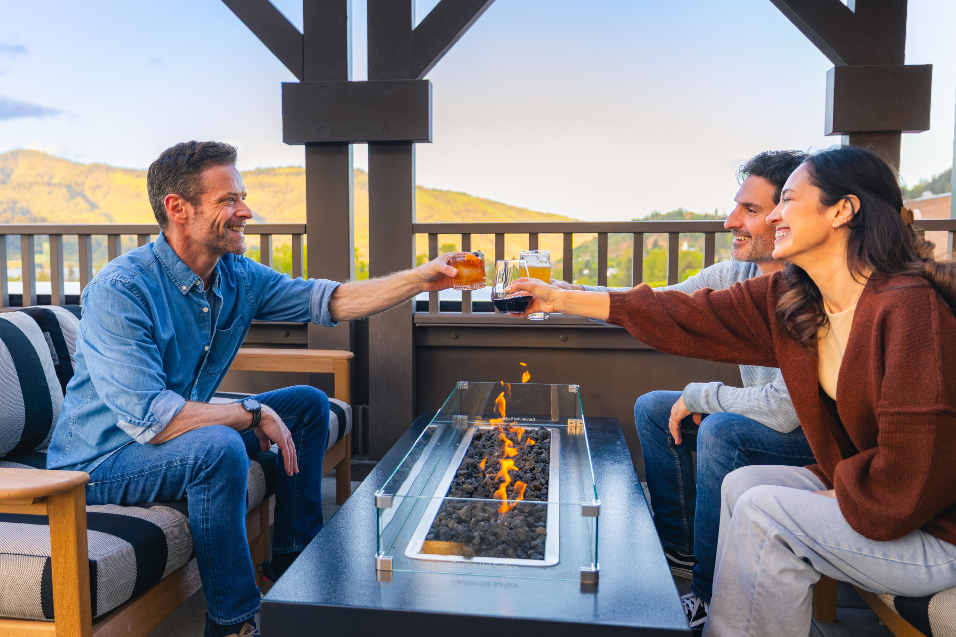 Guests enjoying cocktails around a rooftop fire pit with mountain views at Lightwell Hotel in Hood River, Oregon.