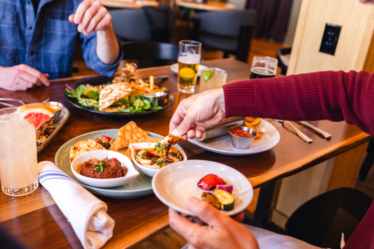 Guests enjoying cocktails and shared plates at Lightwell Hotel’s restaurant and bar in downtown Bend, Oregon.