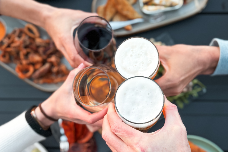Group of travelers sharing a rooftop dinner and cocktails with scenic views at Lightwell Hotel in Hood River, Oregon.